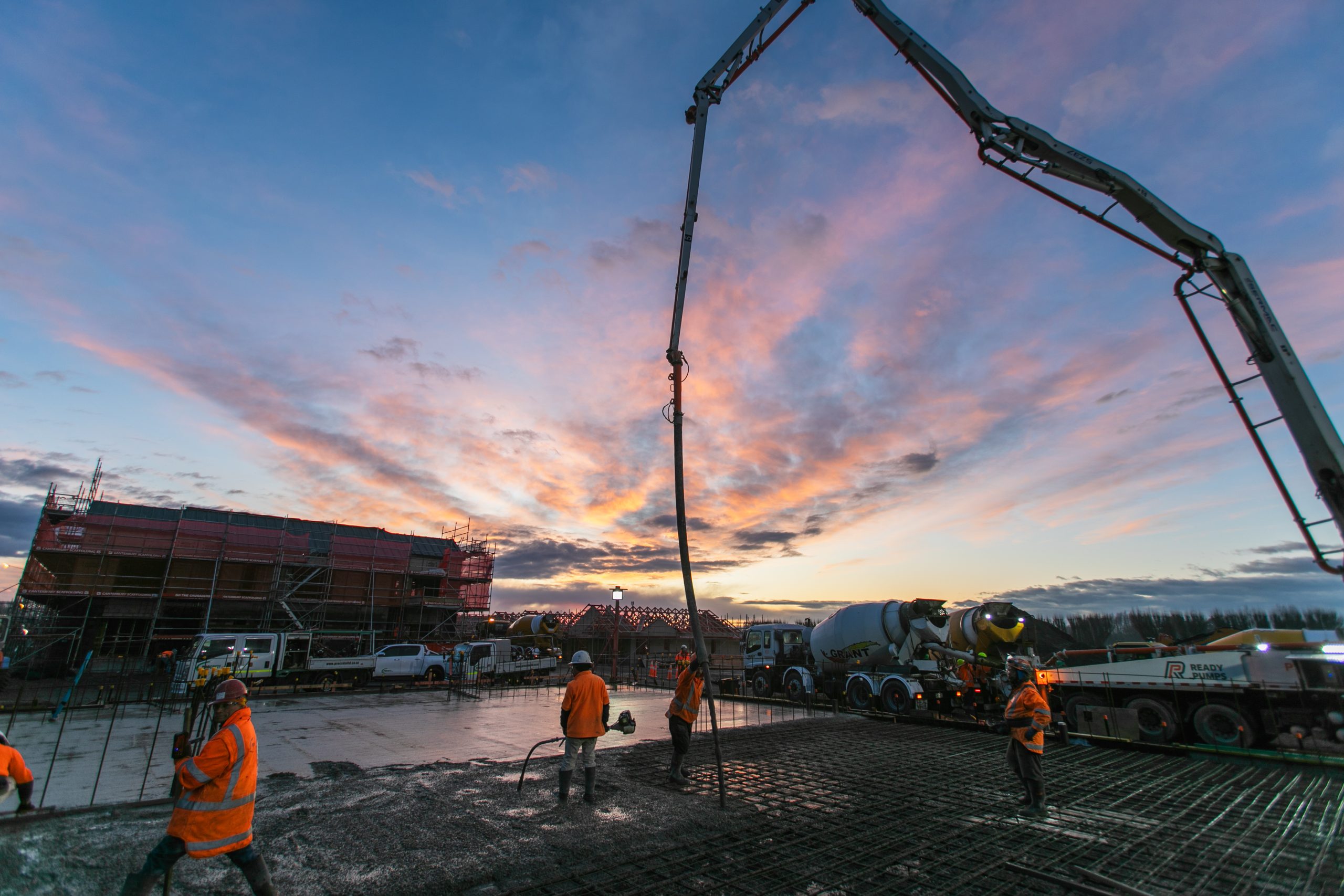 colorful sunrise with concrete pump and workers. photo and videography by Upsite